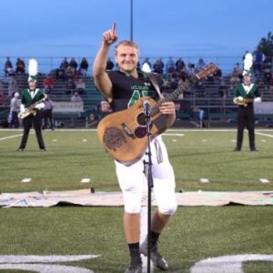 Because no one wanted to sing the national anthem, one high school kid removed his helmet and picked up a guitar.